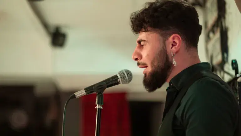cantaor canta delante de publico en espectaculo flamenco